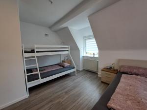 ein Schlafzimmer mit zwei Etagenbetten und einem Fenster in der Unterkunft Ferienhaus Mandelbäumchen in Barth + 21 Fotos