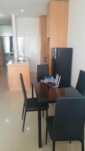 a dining room table with chairs and a kitchen at My Flat 2 in Praia