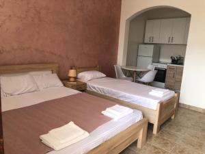 two beds in a small room with a kitchen at Apartman Cmiljanic in Igalo
