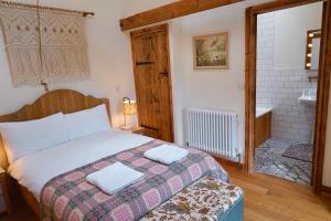 ein Schlafzimmer mit einem Bett mit zwei Handtüchern darauf in der Unterkunft Nest Holiday Hideaway Wren Cottage Stunning Area! in Church Stretton