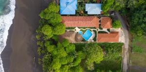 an aerial view of a house with a swimming pool at Fuego del Sol Beachfront Hotel in Jacó