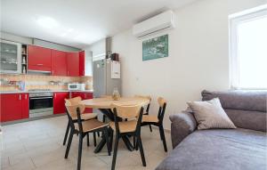 sala de estar con mesa y cocina con armarios rojos en Beautiful Home In Ricice With Lake View, en Kolovrati