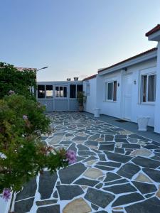 a patio with a stone floor and buildings at Afiartis Avli House in Karpathos Town