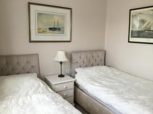 ein Schlafzimmer mit 2 Betten und einer Lampe auf einem Nachttisch in der Unterkunft Strawberry Fields in Cockermouth