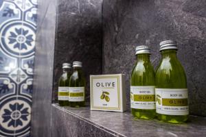 four bottles of olive oil sitting on a shelf at Pelicano Inn Playa del Carmen - Beachfront Hotel in Playa del Carmen