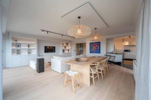 a kitchen and living room with a table and chairs at Morgenzon stijlvol appartement met garage, Knokke in Knokke-Heist