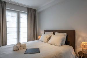 a bedroom with a bed with a book on it at Morgenzon luxueus appartement in Knokke-Heist