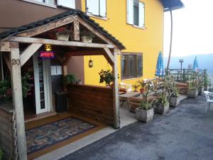 une pergola à l'extérieur d'une maison avec des plantes en pot dans l'établissement Albergo Ristorante K2, à Roana