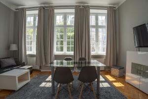 a living room with a glass table and chairs at VIU Postcards from Gdansk in Gdańsk
