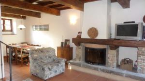 a living room with a tv and a fireplace at Holiday House Casini di Corte in Corfino