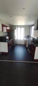 a kitchen with a black tile floor in a room at AUBIGNY appartement centre ville 1e étage in Aubigny-sur-Nère