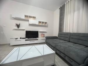Una sala de estar con un sofá y un televisor. en Vlore , Lungomare, en Vlorë