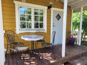 a table and chairs on the porch of a house at Stuga i Borgholms villa in Borgholm