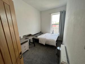 a small bedroom with a bed and a window at Room in new flat in Walsall