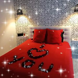 un letto con piumone rosso e un cuore disegnato sopra di Gîte de la Daudière La Grange a Le Boupère