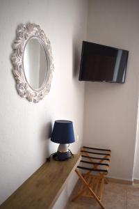 una mesa con una lámpara y un espejo en la pared en Aestas Vergia Apartments 2, en Nea Kalikratia