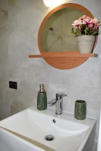 lavabo con espejo y jarrón de flores en Aestas Vergia Apartments 2, en Nea Kalikratia