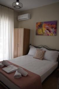 1 dormitorio con 1 cama grande con sábanas blancas en Aestas Vergia Apartments 2, en Nea Kalikratia