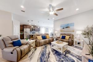 uma sala de estar com sofás e uma ventoinha de tecto em Serenity by the Sea em Saint Augustine
