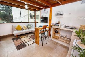 a kitchen and living room with a table and a couch at Acogedor apartamento cerca al mar. in Lima