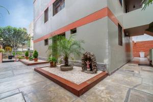 a courtyard of a building with plants and a fireplace at Acogedor apartamento cerca al mar. in Lima