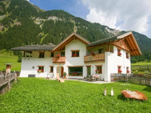 a house in a field with mountains in the background at Ferienhaus Larch Soge Apt Helmuth in Racines