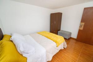 Un dormitorio con una cama con una manta amarilla. en Acogedor apartamento cerca al mar., en Lima