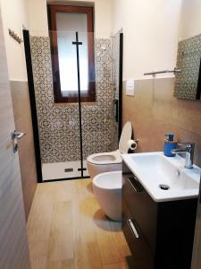 baño con aseo y una cruz en la pared en Casa vacanze Sabbie di Giove, en Patti
