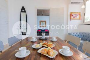 un comedor con una mesa de madera con comida. en Surf Flat, en San Foca