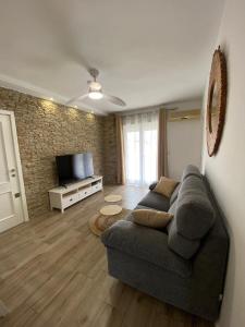 a living room with a couch and a television at Apartamento Playa Oliva Deluxe in Oliva
