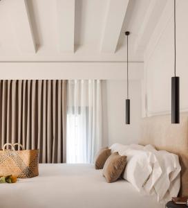 a bedroom with a bed with white sheets and pillows at Room Mate Oliveira - City Centre, Valencia in Valencia
