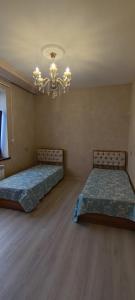 1 dormitorio con 2 camas y lámpara de araña en Caspian Seaside Villa en Sumqayyt