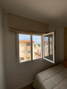 Apartamento Playa Oliva Deluxe في أوليفا: غرفة نوم بسرير ونافذة كبيرة