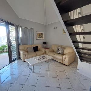 ein Wohnzimmer mit 2 Sofas und einem Tisch in der Unterkunft Resort Loft & Spa Villa #8 in Mandurah
