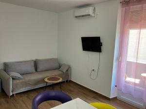 een woonkamer met een bank en een tv aan de muur bij Marie in Zadar