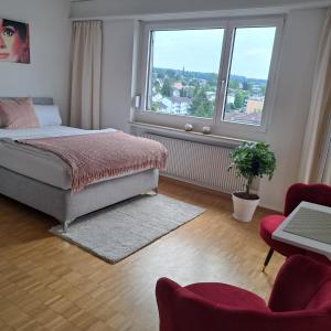 a bedroom with a bed and a large window at Sonniges 1-Zimmerappartement mit Blick über Kreuzlingen in Kreuzlingen
