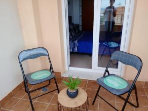 zwei Stühle und eine Topfpflanze vor einem Spiegel in der Unterkunft Mediterráneo lux in Aguadulce