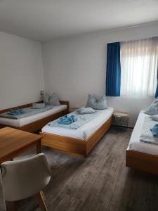 een kamer met drie bedden en een tafel bij Mainstern Hotel in Schonungen