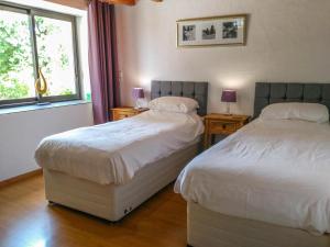 2 Betten in einem Schlafzimmer mit 2 Lampen und einem Fenster in der Unterkunft La Bourriette in Montaigu-de-Quercy