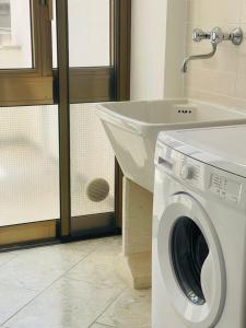 加里波利的住宿－Dimora Chanel Gallipoli 30mt dal mare，一间带盥洗盆的浴室内的洗衣机