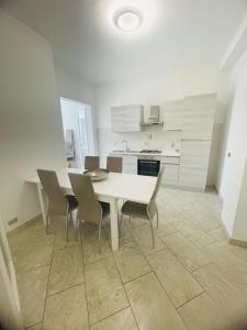 een witte keuken met een witte tafel en stoelen bij Dimora Chanel Gallipoli 30mt dal mare in Gallipoli