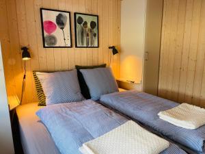 1 dormitorio con 1 cama con sábanas azules y 2 lámparas en Sommerhus Dänemark, en Tranekær