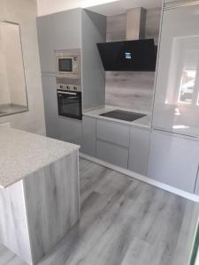 cocina con electrodomésticos de acero inoxidable y suelo de madera en CASA Outeiro 4 en Muros