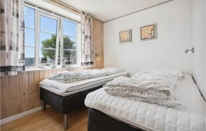 two beds in a room with a window at Gorgeous Home In Rm With Wifi in Bolilmark