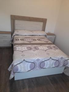 1 dormitorio con 1 cama con cabecero de madera en CASA Outeiro 4 en Muros