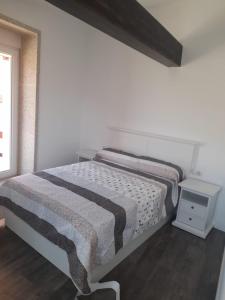 Habitación blanca con cama y mesita de noche en CASA Outeiro 4 en Muros