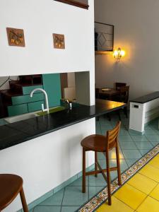 a kitchen with a sink and a counter with chairs at Casa Vista Mare in Capri