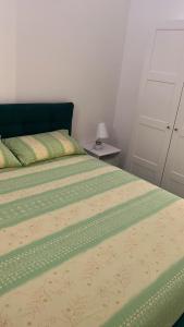 una camera con un letto e un piumone verde e giallo di Casa Vista Mare a Capri