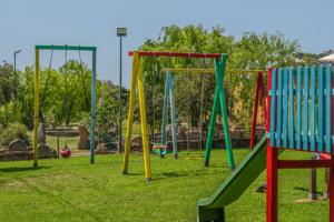 a playground with colorful play equipment in a park at Hotel Airone in Baja Sardinia