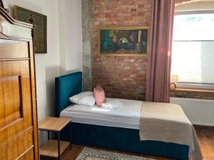 małe łóżko w pokoju z ceglaną ścianą w obiekcie Villa Italiana pokoje z prywatnymi łazienkami & Odnowa Biologiczna w mieście Gdynia